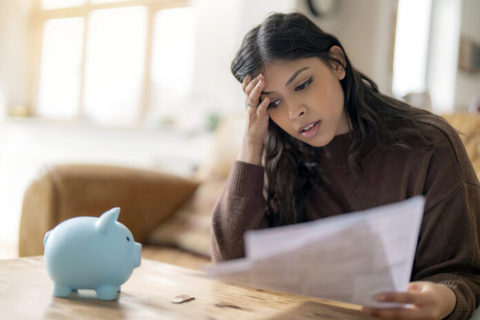 Worried young indian woman reading letter savings employment tax paying energy bill confused upset